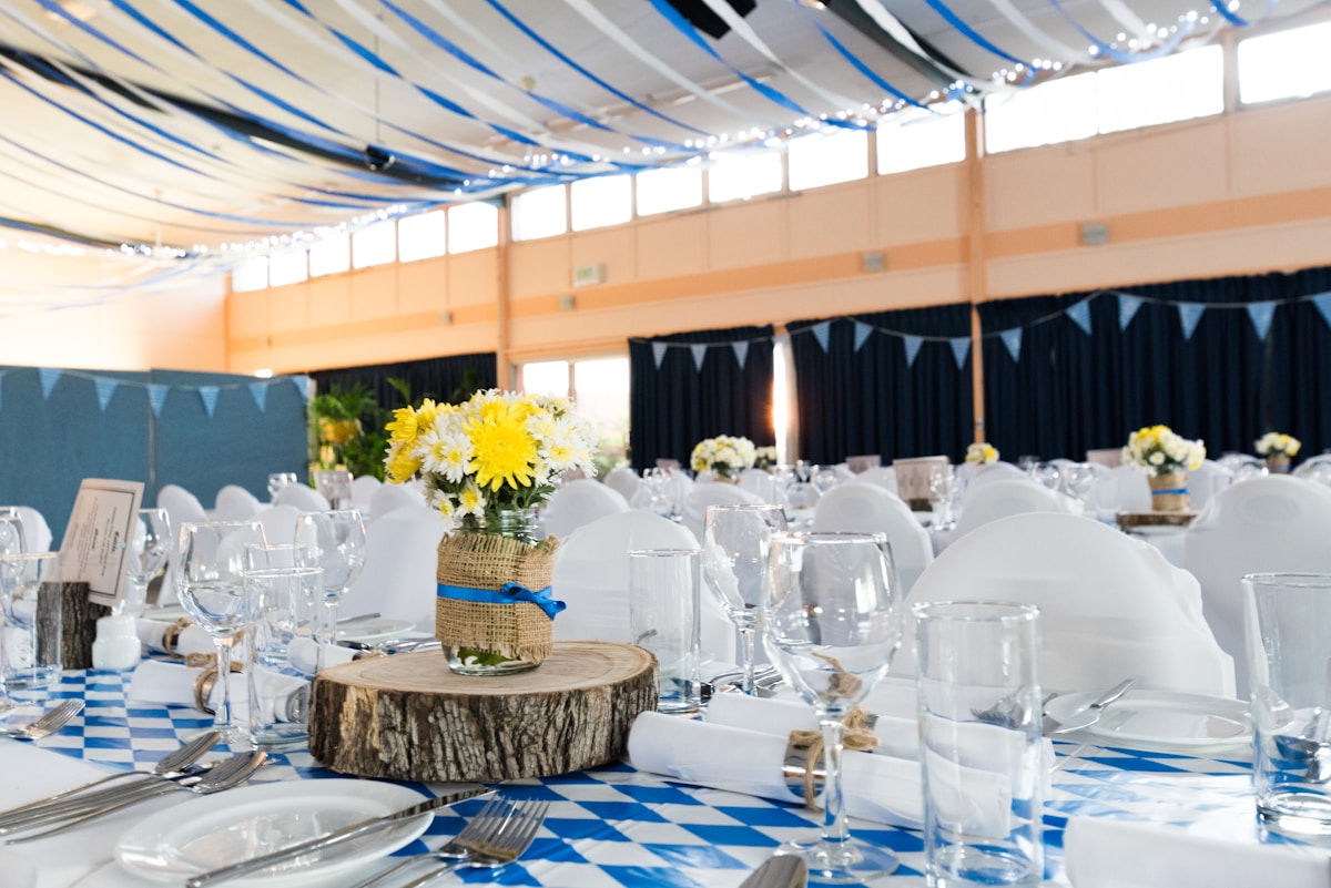 Warm celebration venue with layered table styling and floral decor